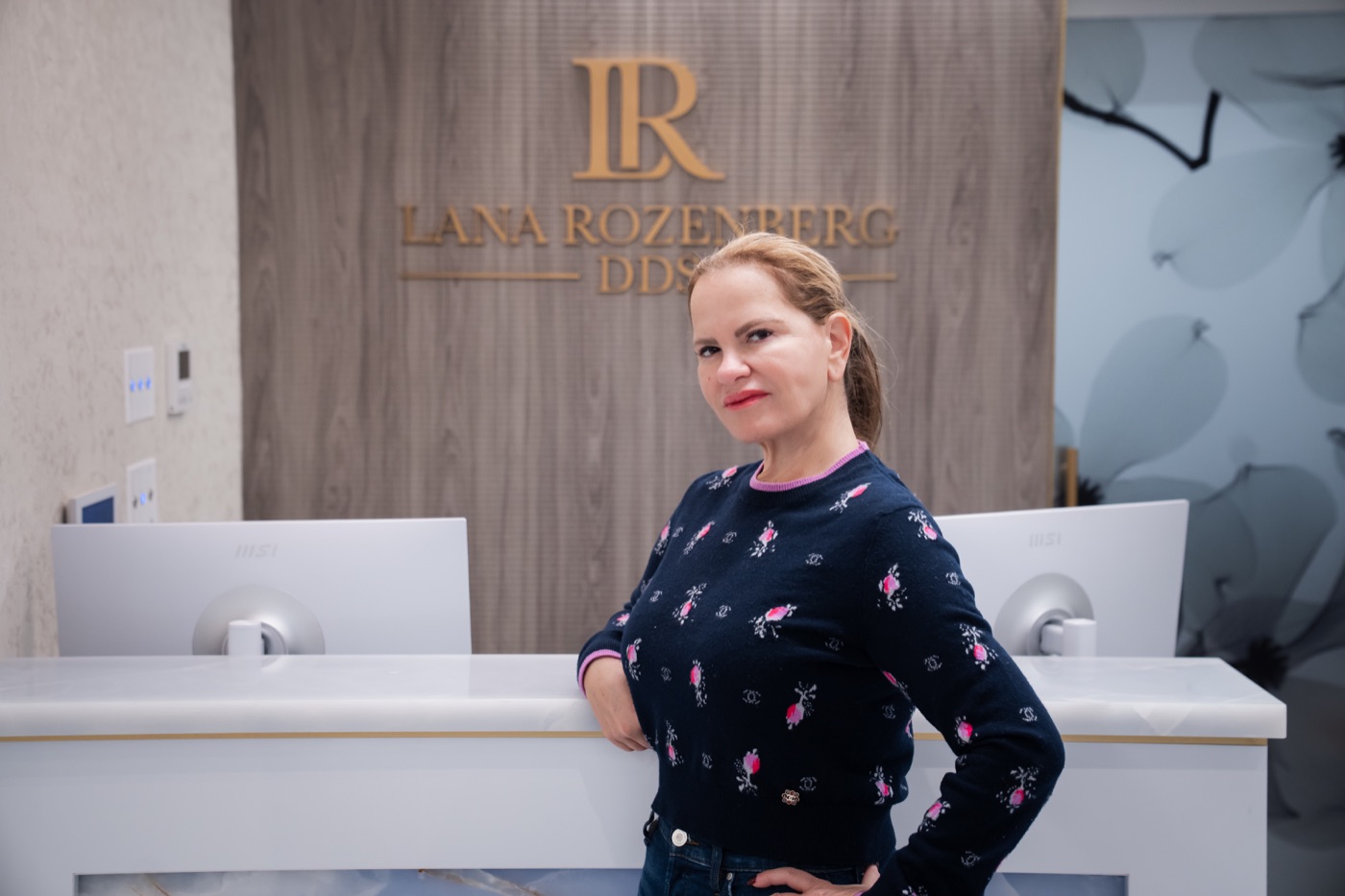 Dr. Lana Rozenberg at the reception desk of Rozenberg Dental NYC
