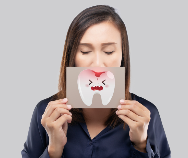 Woman holding broken tooth picture